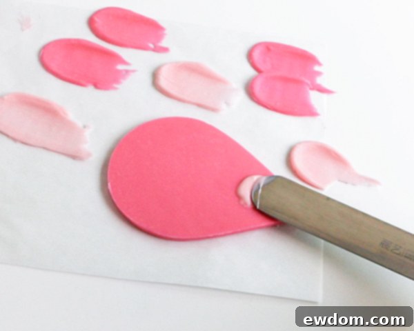 Pink Paradise Flamingo Cake 29 Applying melted pink chocolate to the large tear drop for attaching feathers