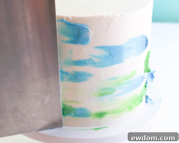 Pink Paradise Flamingo Cake 34 Using an icing smoother to blend the buttercream dots into a watercolor design on the cake