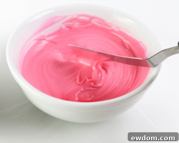 Pink Paradise Flamingo Cake 9 Smearing bright pink chocolate onto parchment paper to create the first brushstroke feather