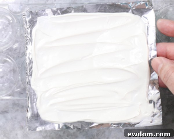 Chocolate Lollipop Ghosts - how to make edible lollipop ghosts for Halloween cakes and cupcakes using white chocolate and suckers | by Erin Gardner for TheCakeBlog.com