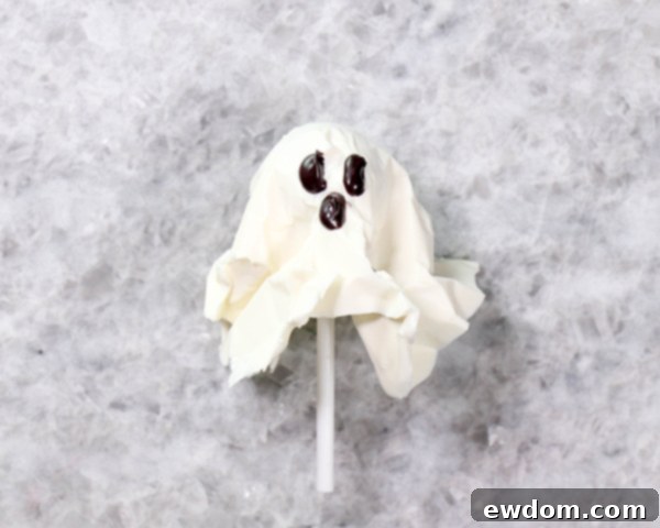 Chocolate Lollipop Ghosts - how to make edible lollipop ghosts for Halloween cakes and cupcakes using white chocolate and suckers | by Erin Gardner for TheCakeBlog.com