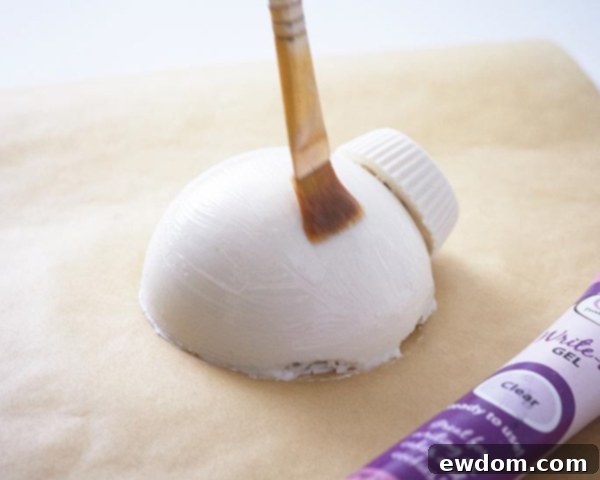 Applying piping gel to Christmas Ornament Cakes for sanding sugar