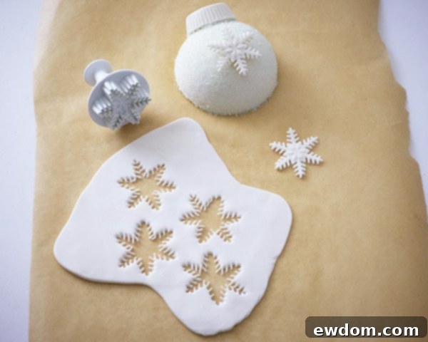 Cutting fondant snowflakes with a plunger cutter for cake decoration