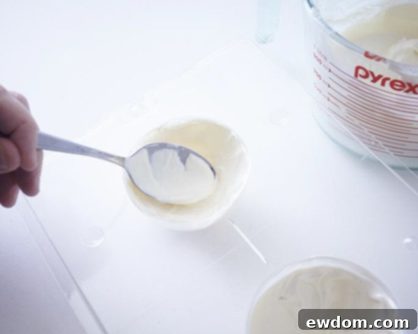 Lining ball mold with melted candy coating for ornament cakes