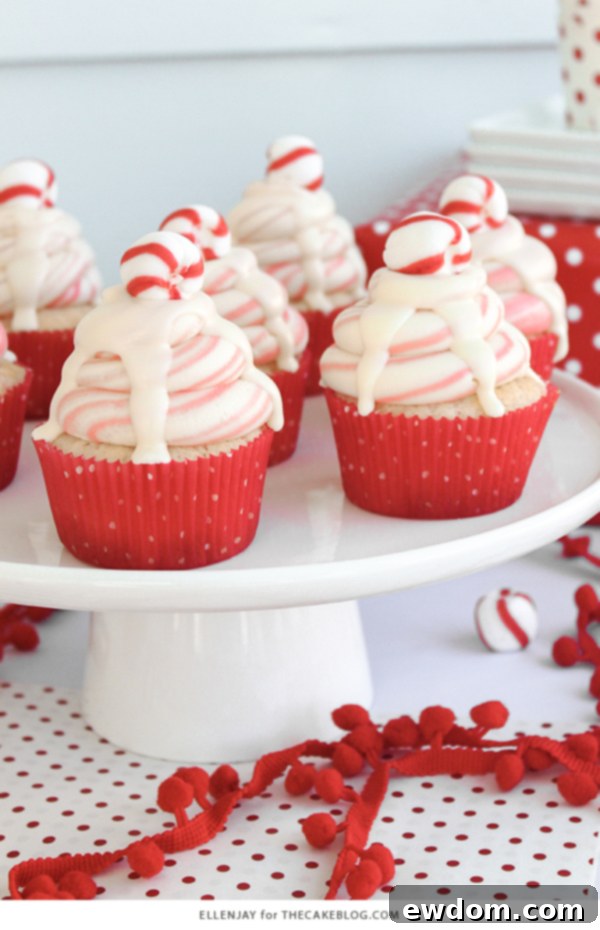 Close-up of a White Chocolate Peppermint Cupcake showing the white cake base, crushed candy canes, and the festive red and white buttercream swirl.