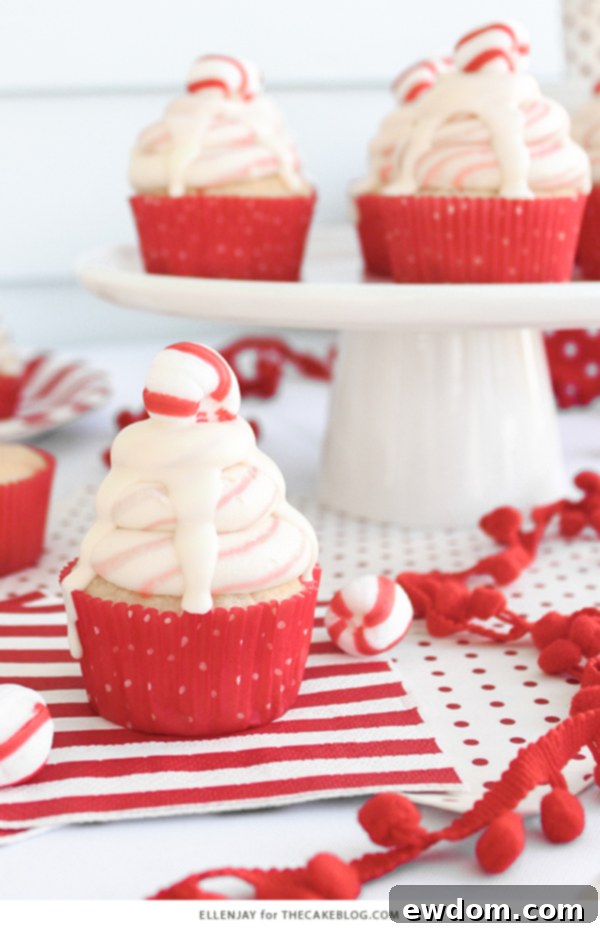 A festive display of White Chocolate Peppermint Cupcakes with holiday decorations in the background, emphasizing their role as a perfect Christmas treat.
