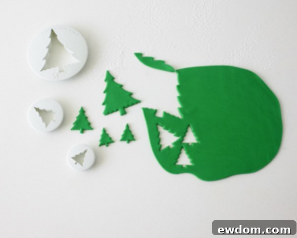 Decorating Snow Globe Cookies - Rolling out green fondant for Christmas tree cutouts by Cakegirls for TheCakeBlog.com