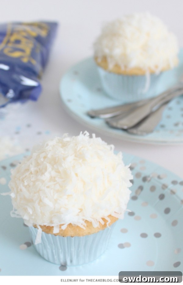 Coconut Cupcakes - fluffy coconut cupcakes made with coconut milk and topped with smooth coconut buttercream and coconut flakes | by ellenJAY for TheCakeBlog.com