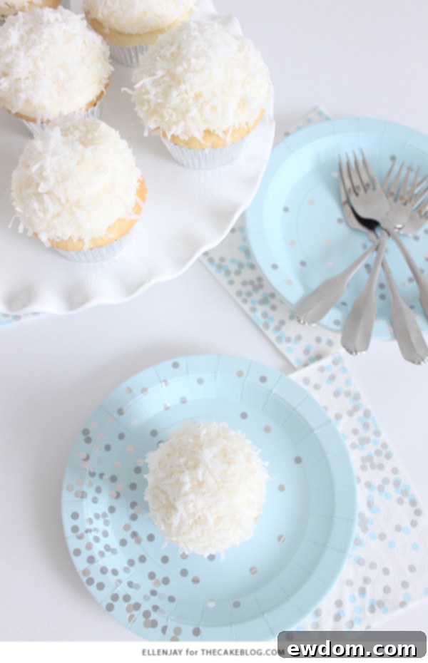 Coconut Cupcakes - fluffy coconut cupcakes made with coconut milk and topped with smooth coconut buttercream and coconut flakes | by ellenJAY for TheCakeBlog.com