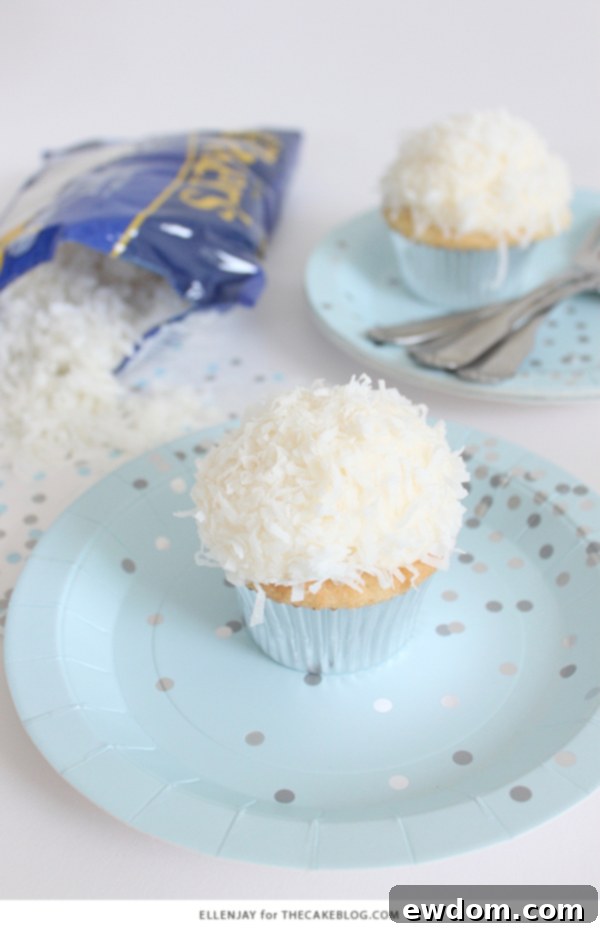 Coconut Cupcakes - fluffy coconut cupcakes made with coconut milk and topped with smooth coconut buttercream and coconut flakes | by ellenJAY for TheCakeBlog.com