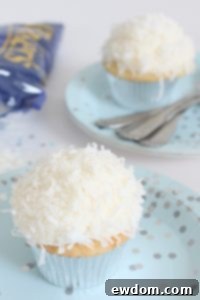 Coconut Cupcakes - fluffy coconut cupcakes made with coconut milk and topped with smooth coconut buttercream and coconut flakes | by ellenJAY for TheCakeBlog.com