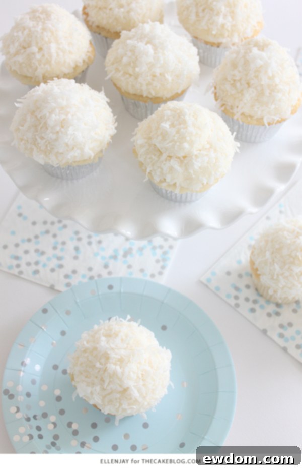 Coconut Cupcakes - fluffy coconut cupcakes made with coconut milk and topped with smooth coconut buttercream and coconut flakes | by ellenJAY for TheCakeBlog.com
