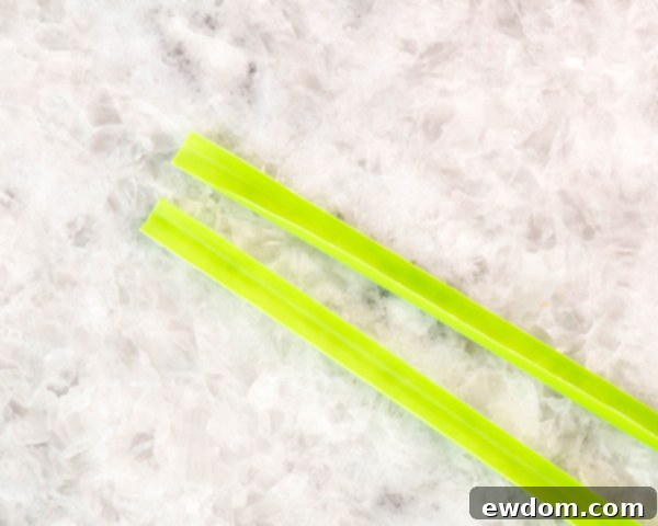 Arrange all cupped straw molds on a cookie sheet, ensuring the open side faces up, ready to be filled with melted chocolate.