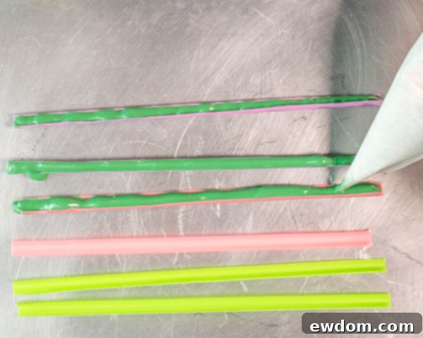 Fill pre-cut straw molds with melted dark green coating chocolate using a piping bag, then chill until hardened to form stems.