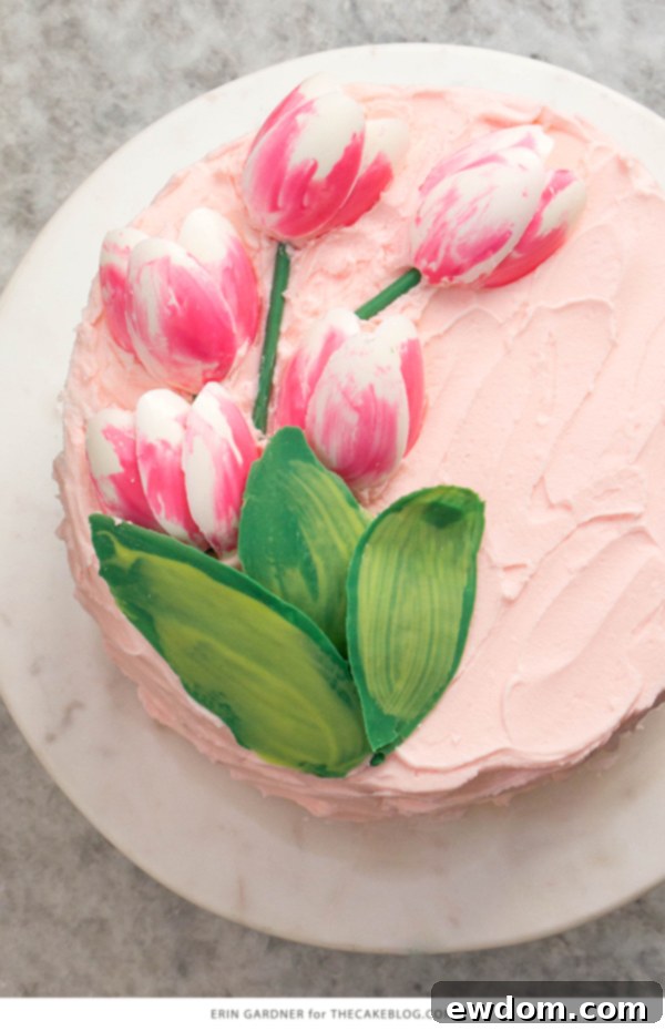 Slide chocolate stems under petals, pipe buttercream mounds for leaves, then gently tuck leaves into place to complete the tulip bouquet.