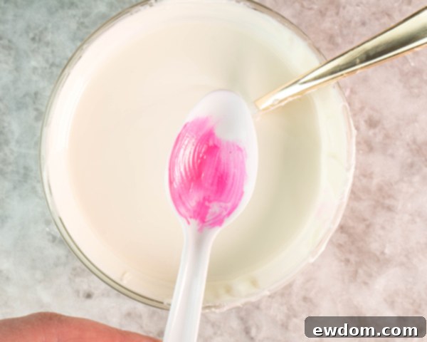 Fill pink-painted spoons with melted white chocolate, ensuring full coverage, then tap excess and chill until fully hardened.