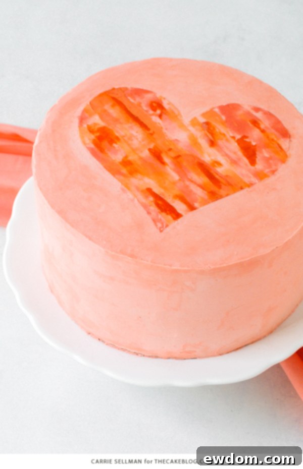 Watercolor Heart Cake - how to paint a watercolor heart cake using buttercream frosting and a parchment paper stencil | by Carrie Sellman for TheCakeBlog.com