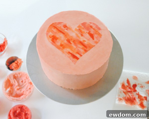 Watercolor Heart Cake - how to paint a watercolor heart cake using buttercream frosting and a parchment paper stencil | by Carrie Sellman for TheCakeBlog.com