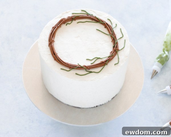 Spring Blossom Wreath Cake 11 Dark green buttercream branches piped over two-thirds of the brown grapevine wreath base on the Spring Wreath Cake.