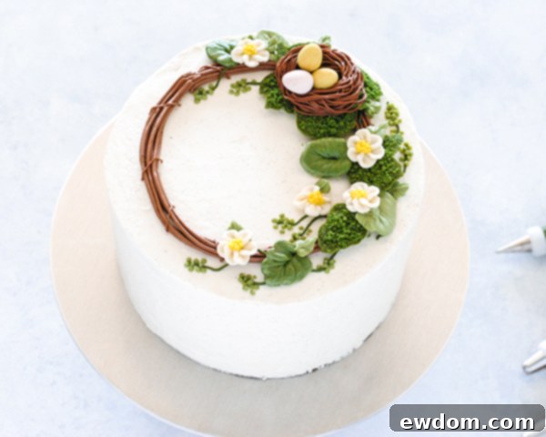 Spring Blossom Wreath Cake 18 The Spring Wreath Cake with piped filler leaves and small green berries, adding final touches and depth to the design.