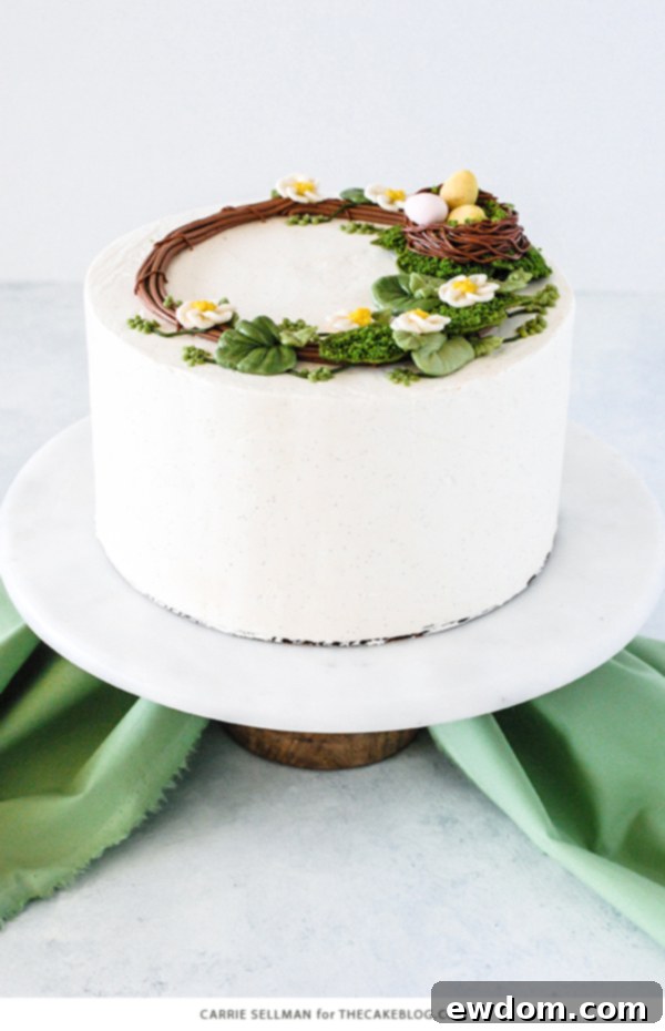 Spring Blossom Wreath Cake 4 An overhead view of the finished Spring Wreath Cake, highlighting the intricate details of the buttercream wreath, the cozy bird's nest, and the scattered cookie moss.