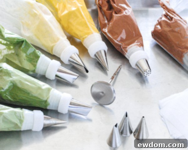 Spring Blossom Wreath Cake 7 Piping bags filled with various colored buttercreams, fitted with couplers and ready for decorating the Spring Wreath Cake.