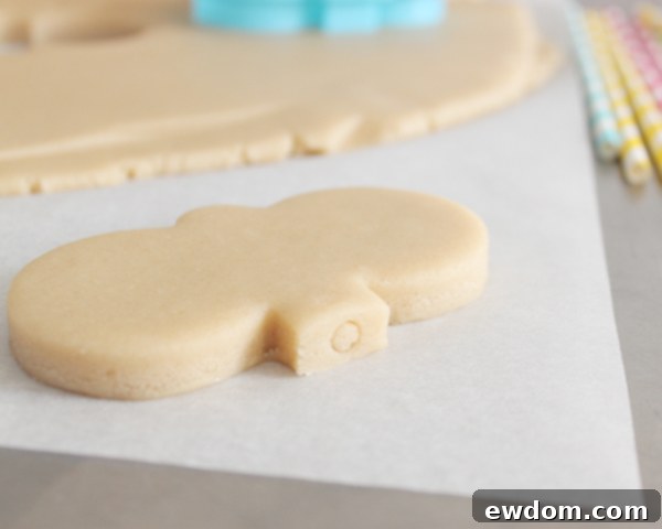Raw bunny cookie pops with sticks placed on a parchment-lined baking sheet