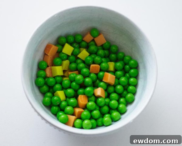 Mid-Century Meal Cake 10 Close-up of candy vegetables: colorful Starburst carrots and corn mixed with green Sixlets, ready to be placed on the TV Dinner Cake. By Cakegirls for TheCakeBlog.com