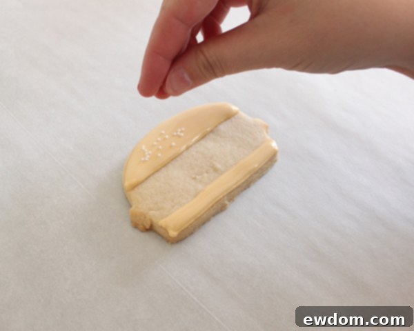 Piping a textured brown royal icing hamburger patty