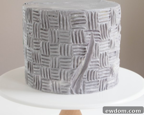 Further refining buttercream stems on cake, demonstrating spatula technique