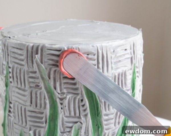 First step in creating a buttercream petal: pressing a dollop onto the cake