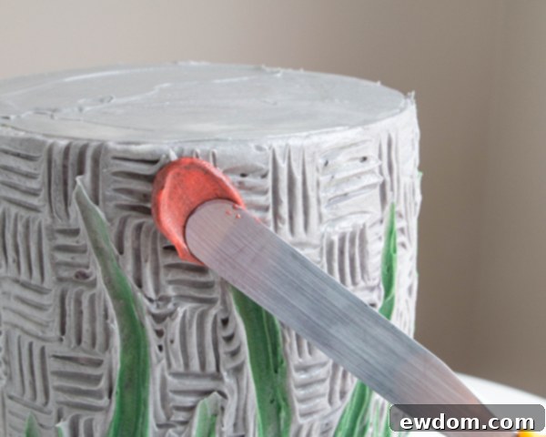 Pulling the spatula away to form a textured buttercream petal on the cake