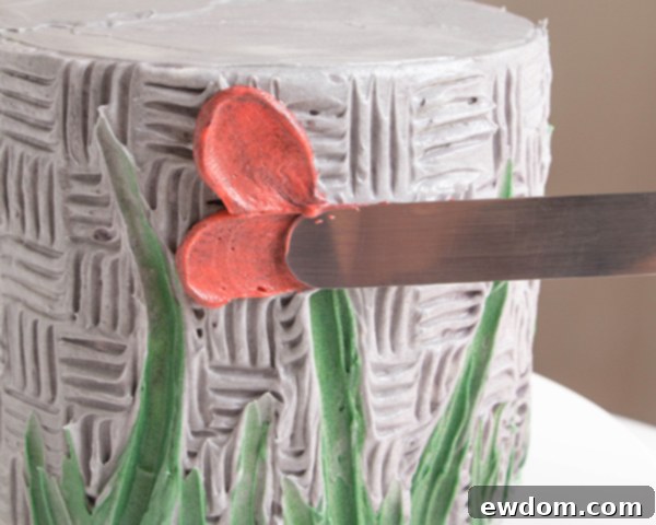 Creating a third petal, continuing the overlapping technique for a multi-layered buttercream flower