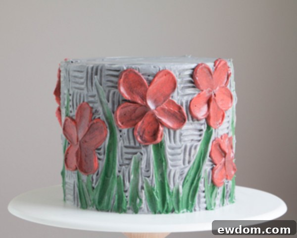 Multiple buttercream palette knife painted flowers adorning the cake, showcasing a full artistic design