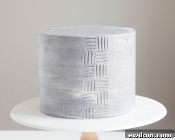 Demonstrating horizontal fork texture technique on a buttercream cake, interlocking with vertical strokes