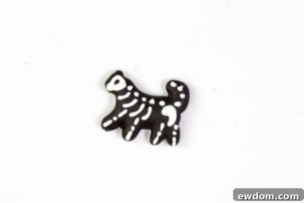 Another example of a white chocolate skeleton piped onto a chocolate-covered animal cracker, showcasing artistic license for a fun effect | by Erin Gardner for TheCakeBlog.com