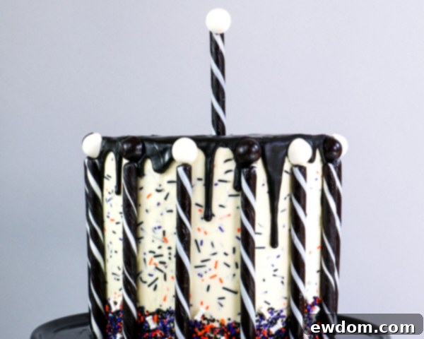 Topping candy sticks with alternating black and white licorice rounds, adding a decorative element to the carousel design | by Erin Gardner for TheCakeBlog.com