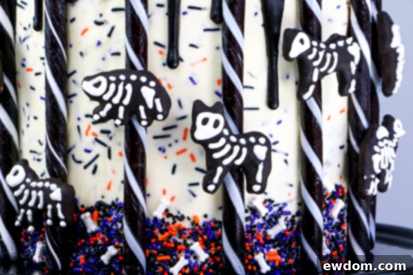 The final touch: securing a licorice drop to the central candy stick, completing the enchanting carousel design of the Halloween cake | by Erin Gardner for TheCakeBlog.com