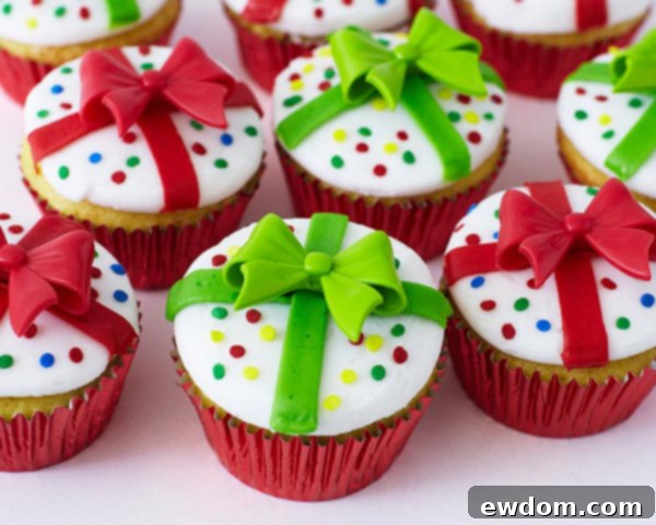 Close-up of a Christmas Present Cupcake showing a vibrant red novelty bow ring topper and sprinkles, designed for easy holiday decorating.