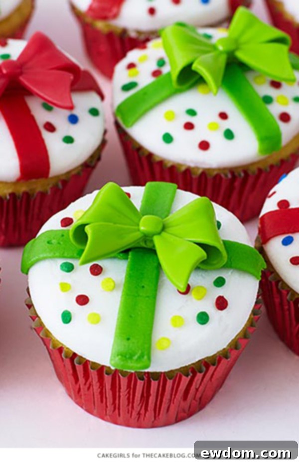 Array of completed Christmas Present Cupcakes, showcasing red and green frosting ribbons, sprinkles, and novelty bow rings, ready for holiday festivities.