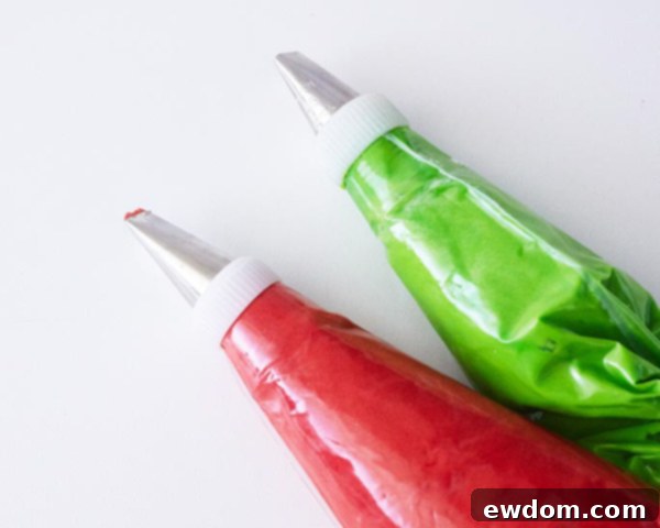 Second step in decorating Christmas Present Cupcakes: piping a red criss-cross ribbon design on an iced cupcake using a flat decorating tip.