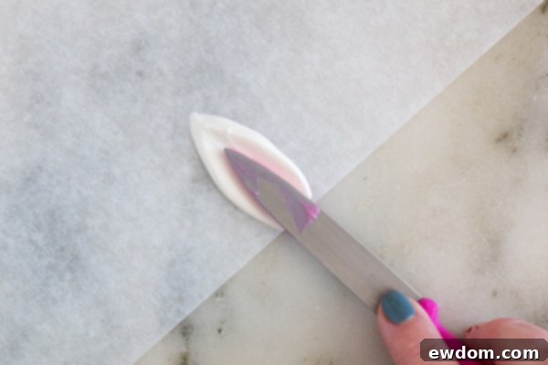 Dipping the smaller knife into melted pink chocolate for the inner ear detail.