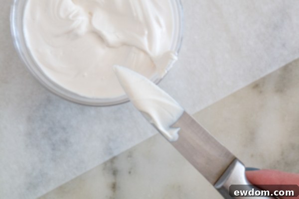 The technique of pressing the chocolate-coated knife onto parchment and pulling it to form a bunny ear shape.