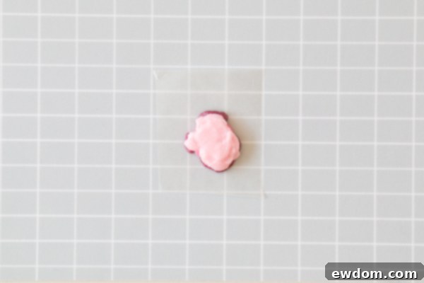 Chic Leopard Buttercream 11 Applying pale pink buttercream to the back of a chilled leopard spot transfer