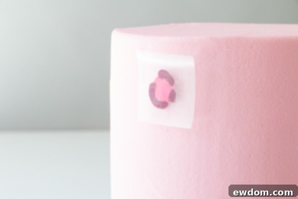 Chic Leopard Buttercream 12 Pressing buttercream leopard spots onto the side of a chilled pink cake