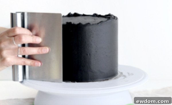 Sorceress's Potion Cake 12 Smoothing black buttercream on the sides of the cake with an icing smoother