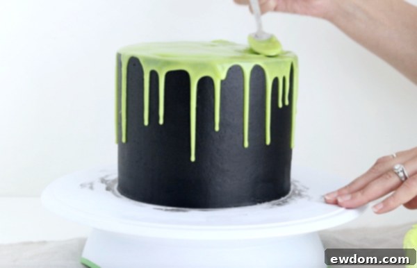 Sorceress's Potion Cake 15 Spreading green ganache on top of the cauldron cake to complete the bubbling effect