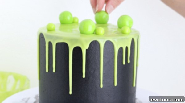Sorceress's Potion Cake 16 Decorating the Witch Cauldron Cake with green gumballs for bubbling effect