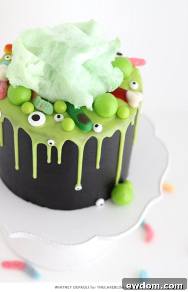 Sorceress's Potion Cake 5 Side view of the Witch Cauldron Cake with dripping green ganache and gummy candies