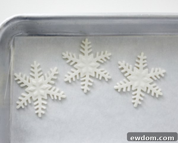 Enchanted Snowflake Cake 9 Newly cut fondant snowflakes drying on parchment paper